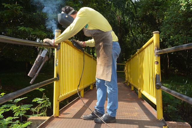 Servidor da Diretoria de Obras no momento da solda da proteção lateral da passarela