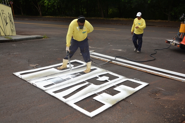 Servidores do Departamento de Trânsito durante a pintura da sinalização em esquina da avenida João Paccola