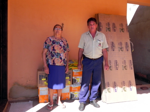 Rosa Maria Alexandrina e servidor José Medola, na entrega de materias de construção a moradora afetada pela enchente
