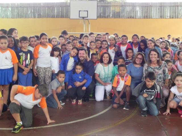 No centro, o prefeito Prado e a diretora Neusa junto às crianças antes do início das aulas