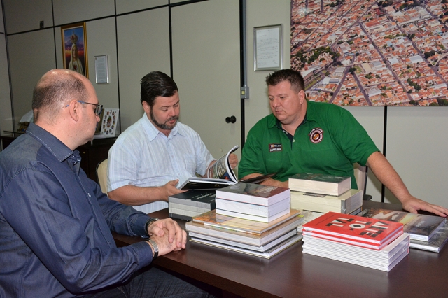 Diretor de Cultura, Marcelo Maganha, o prefeito Prado e Pitoco com parte do lote de livros doados pela Secretaria da Cultura