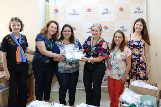 Vice-prefeita Cintia e técnica do fundo social do estado, Lucia, entregam os uniformes do projeto Costurando o Futuro para diretora de creche de Alfredo Guedes