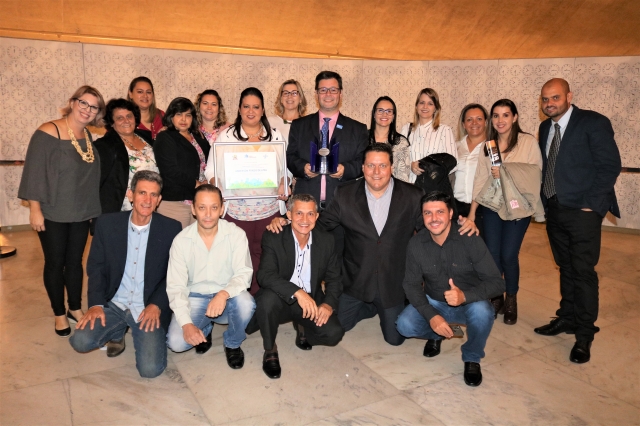 Prefeito Anderson Prado com troféu e servidores públicos envolvidos com a ação municipal que foi premiada