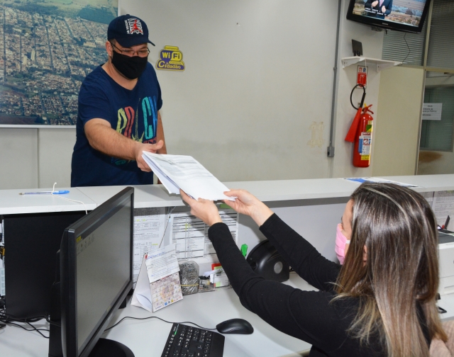 Cidadão entrega documentos no balcão de atendimento da Prefeitura; a partir de segunda, local funciona das 7h30 às 17h