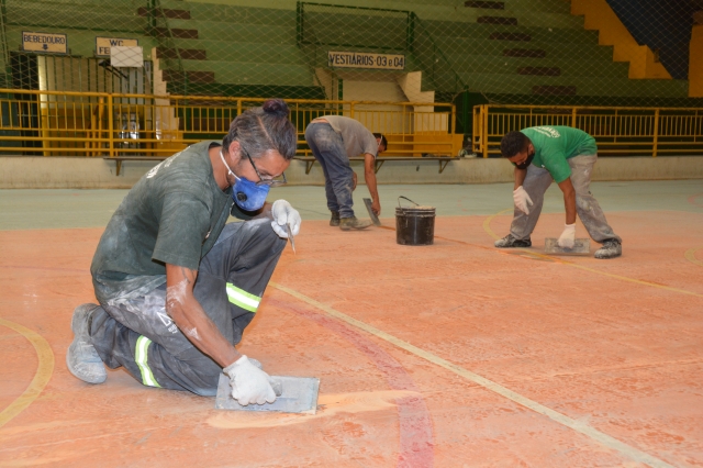 Funcionários da empresa contratada pela prefeitura durante os serviços no piso da quadra do Ginásio Tonicão