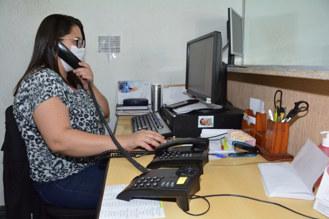 Servidora do setor de Agendamento de Transporte da Saúde durante atendimento telefônico para agendamento da viagem