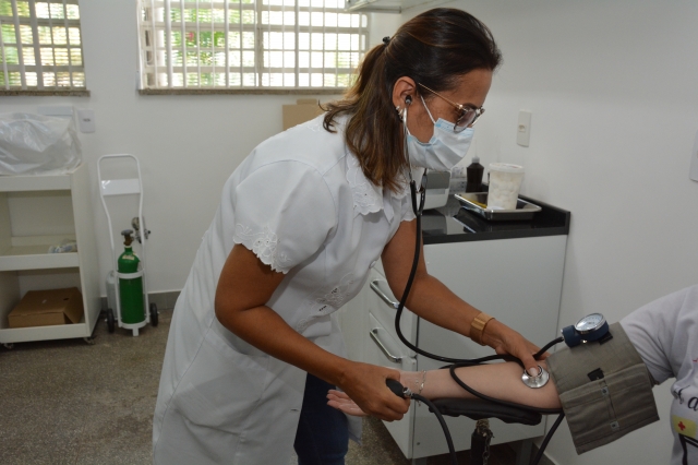 Na foto, servidora durante procedimento para aferição de pressão